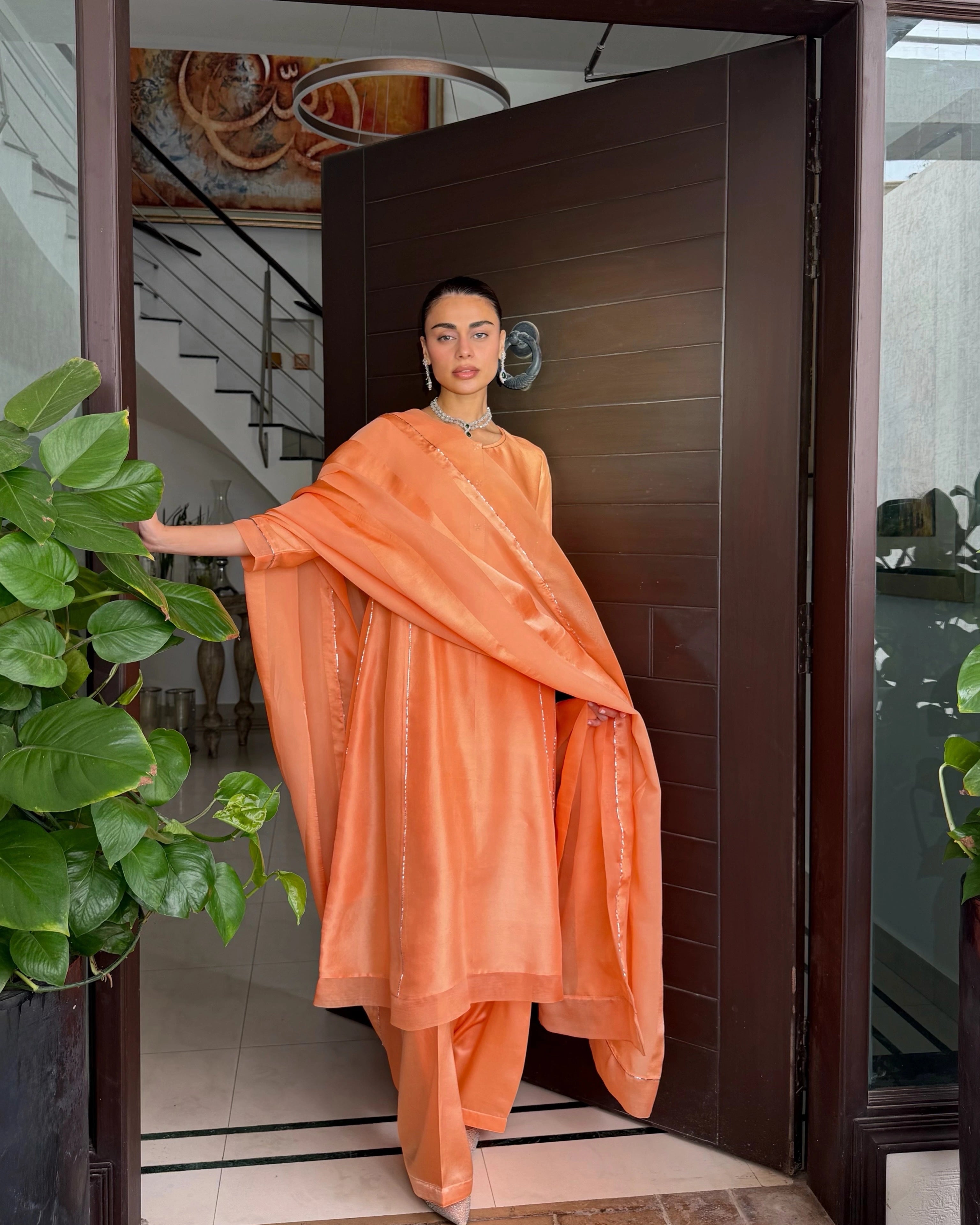 Lincoln Paris Gerua Riwaz Set featuring intricate embroidery and vibrant colors, displayed on a mannequin.