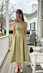 Lincoln Paris Sage Linen Dress displayed on a hanger with a flowing, lightweight fabric and subtle texture.