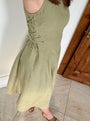 Lincoln Paris sage linen dress hanging on a wooden hanger, showcasing lightweight, breathable fabric and relaxed fit.