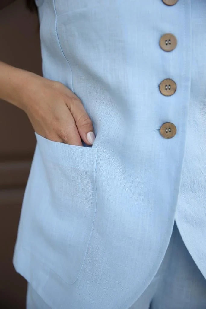 Soft cyan cotton linen bedding set by Lincoln Paris, featuring neatly folded sheets and pillowcases on a cozy bed.