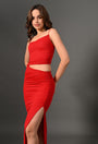 Woman wearing stylish red asymmetrical cutout dress with side slit against gray background